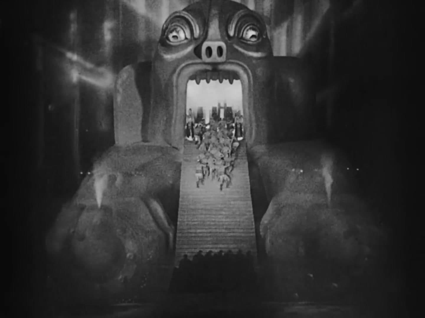 The machine as a gaping mouth swallowing a column of workers, a still from Metropolis